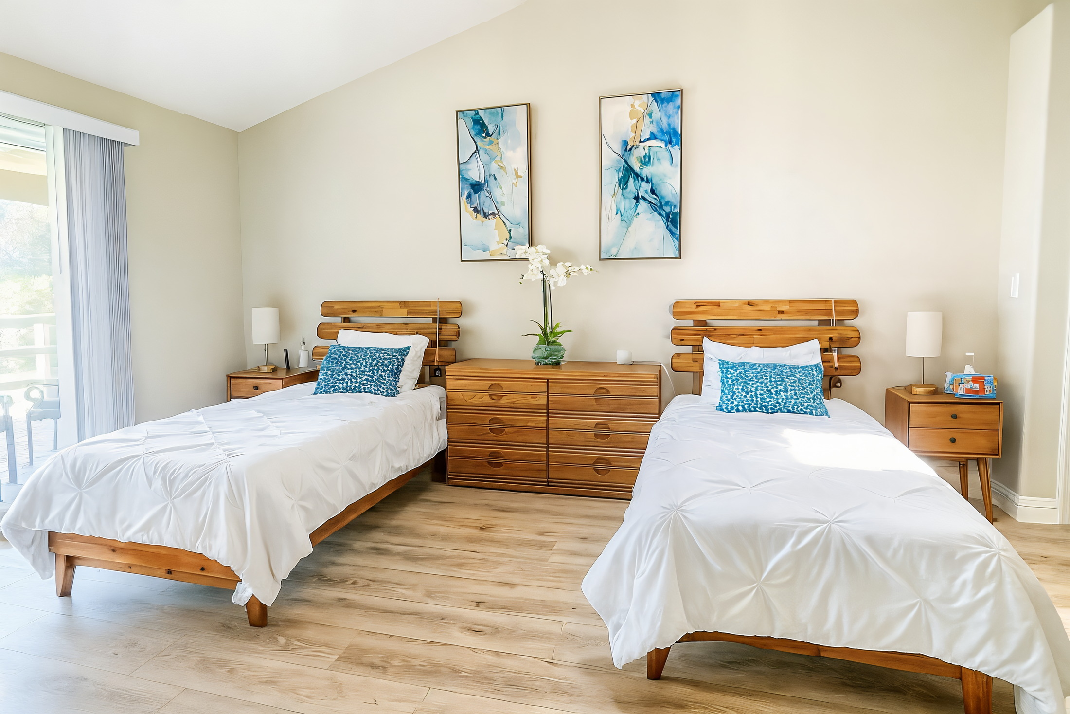 Bedroom with twin beds and coastal artwork